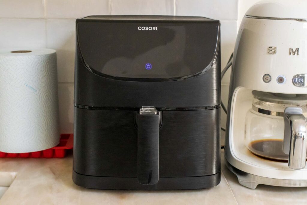 Cosori Air Fryer Surrounded between a Paper Towel Roll and Coffee Maker