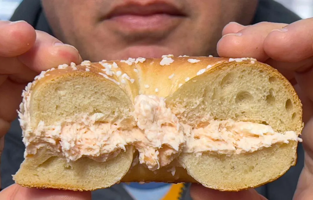 Bagel with Lox Spread in Hands at Murrays Bagels in New York City