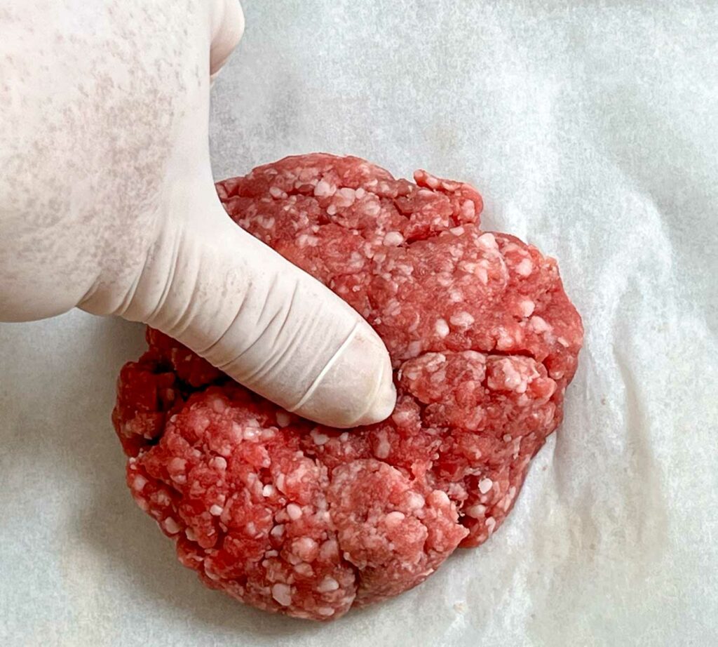 Creating a thumb indentation on a raw burger patty