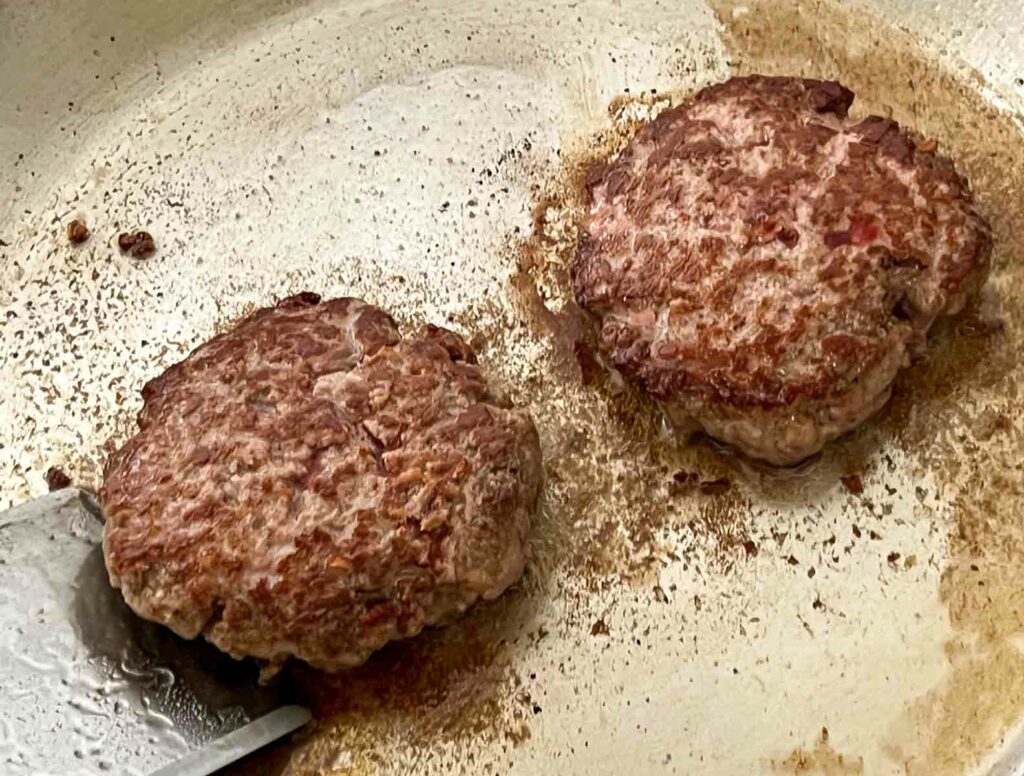 Finished burgers in a frying pan