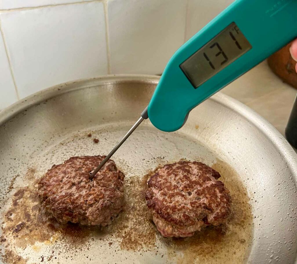 Measuring the temperature on burgers in a pan