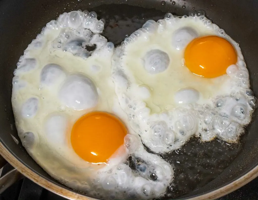 Sunny Side Up eggs cooking in a frying pan