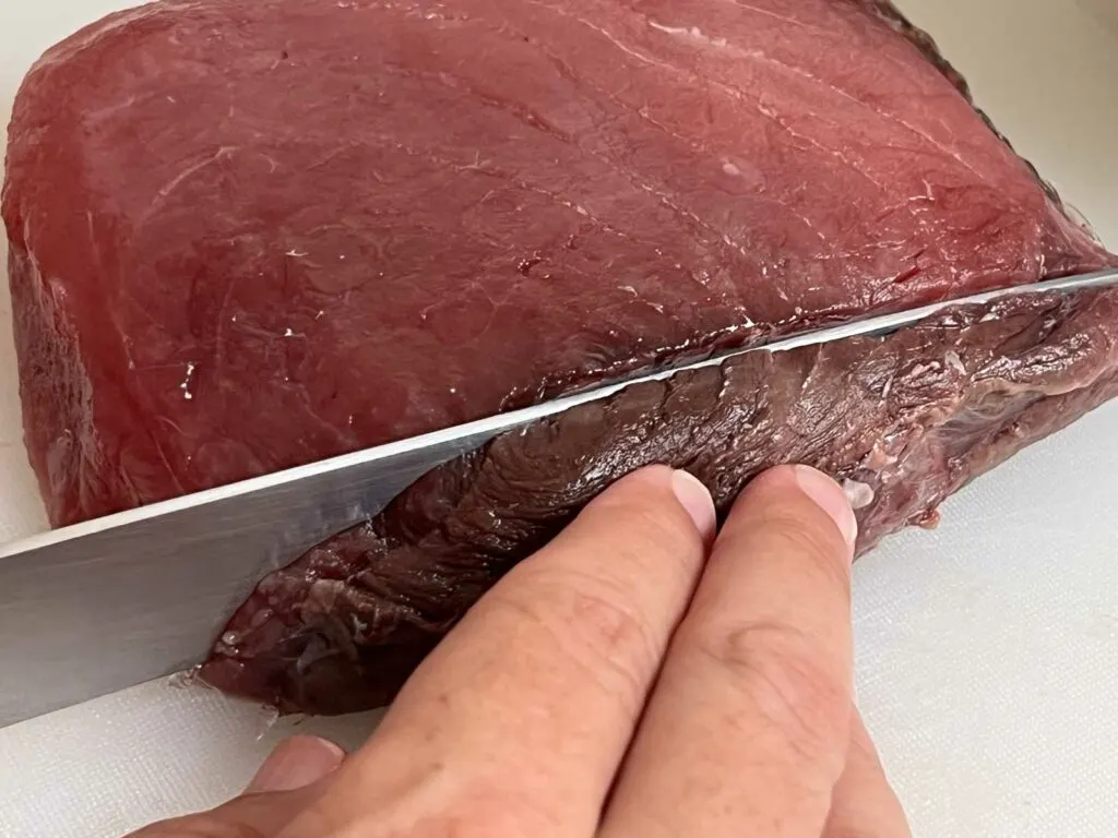 Cutting the bloodline off tuna loin
