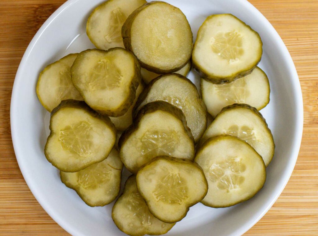 Dill pickles sliced on a white plate