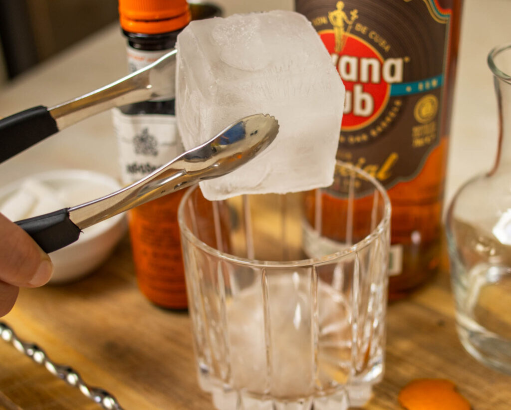 Dropping a Jumbo Ice Cube into a Rum Old Fashioned Cocktail