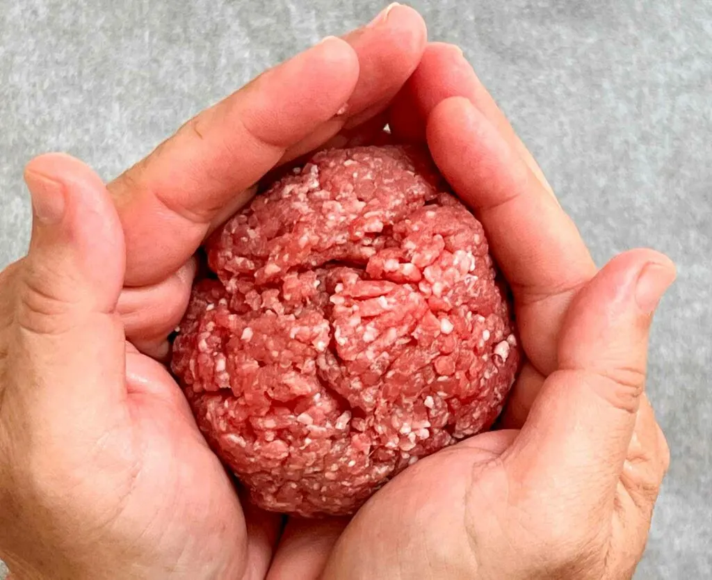 Molding ground meat into a ball for making hamburgers