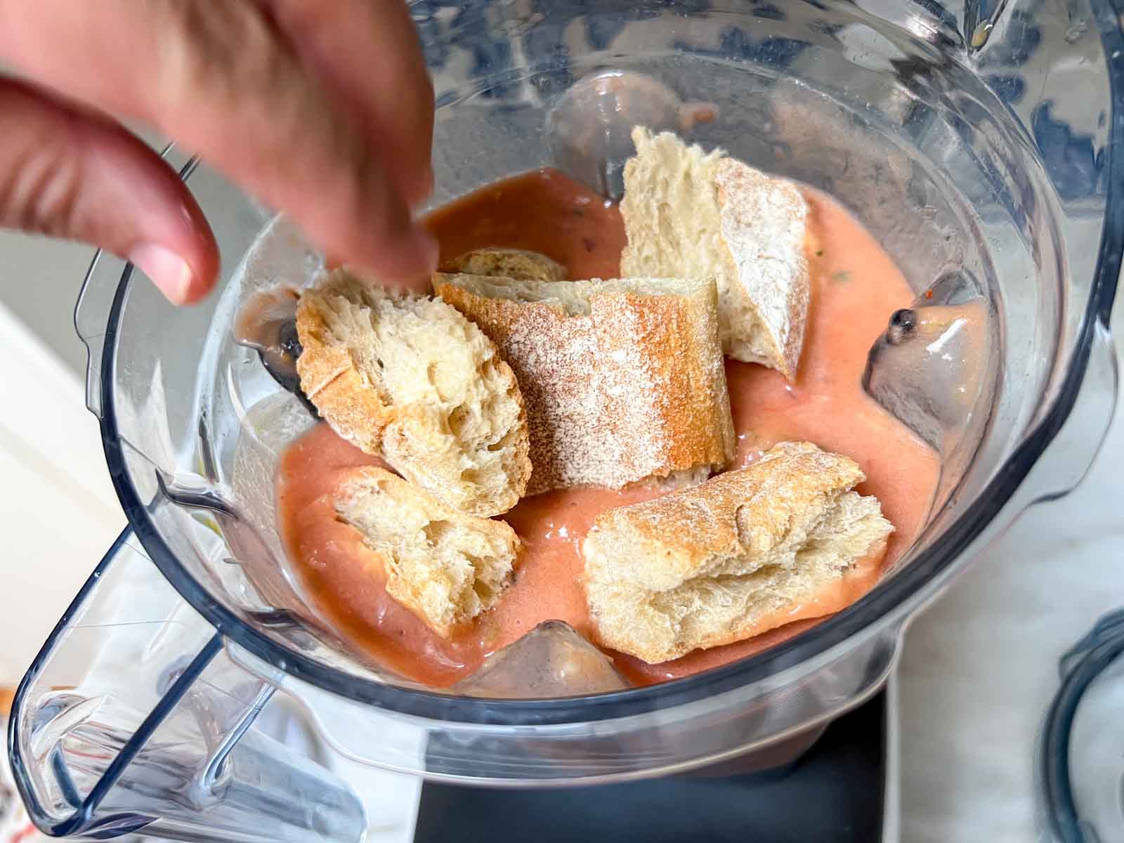 Placing stale bread in a blender for gazpacho