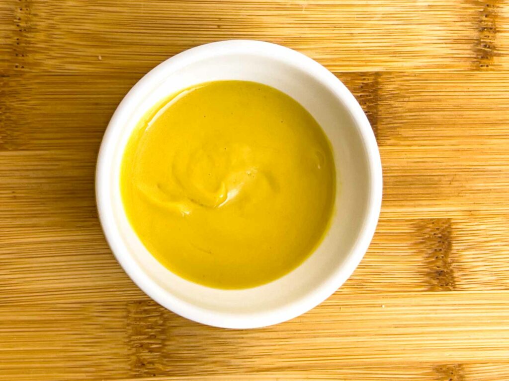 Yellow mustard in a white bowl