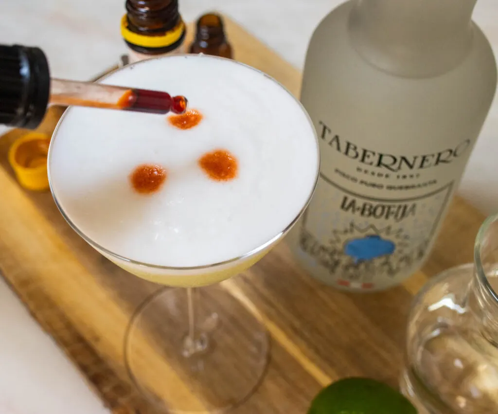 Garnishing a Pisco Sour with Angostura Bitters Eye Dropper