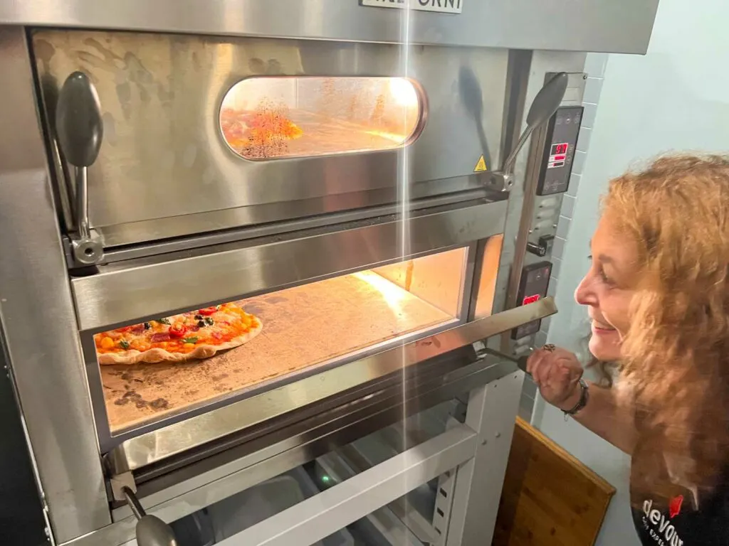 Mindi Appreciates Pizza in Oven at Rome Pizza Making Class