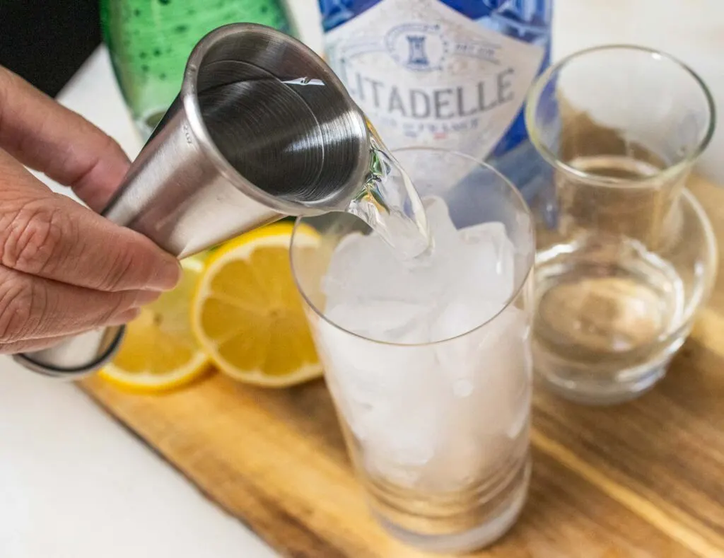 Pouring Gin into a Tom Collins Cocktail