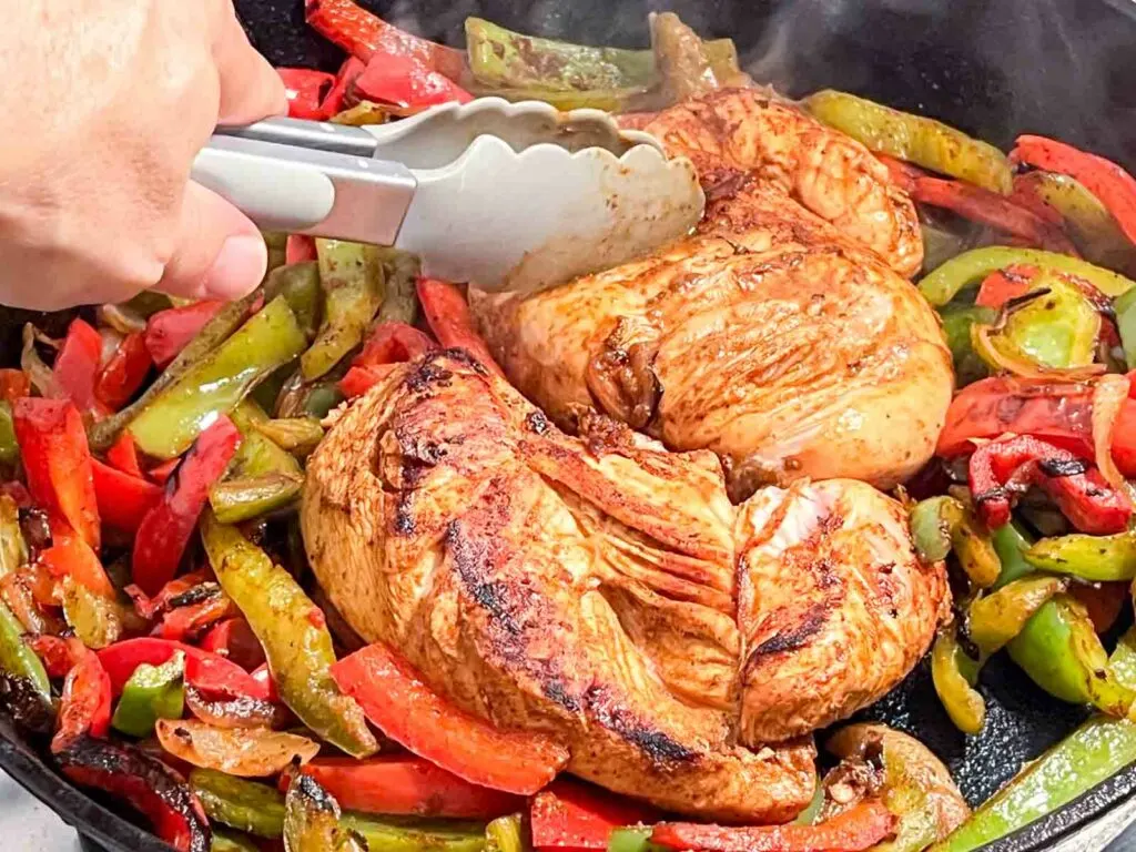 Close up of Chicken grilling for Chicken Fajitas in a Cast Iron Skillet