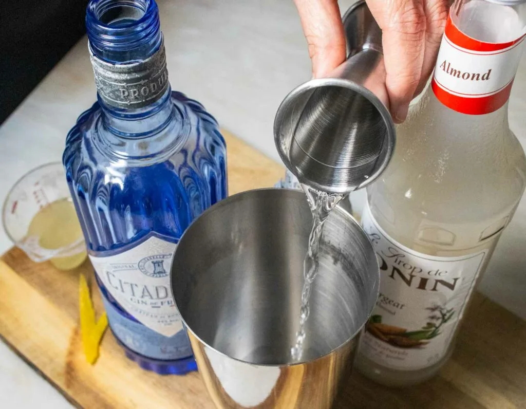 Pouring Gin into an Army and Navy Cocktail