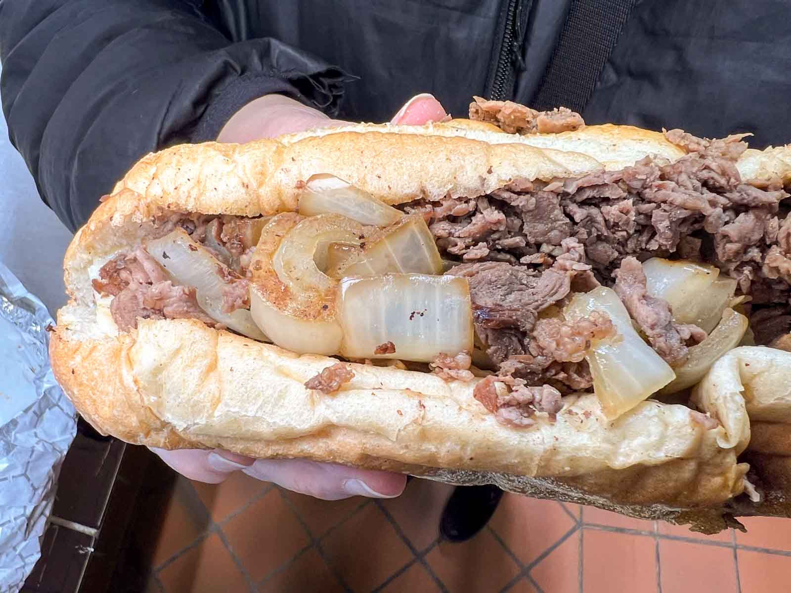 Holding a Cheesesteak at Jims West in Philadelphia