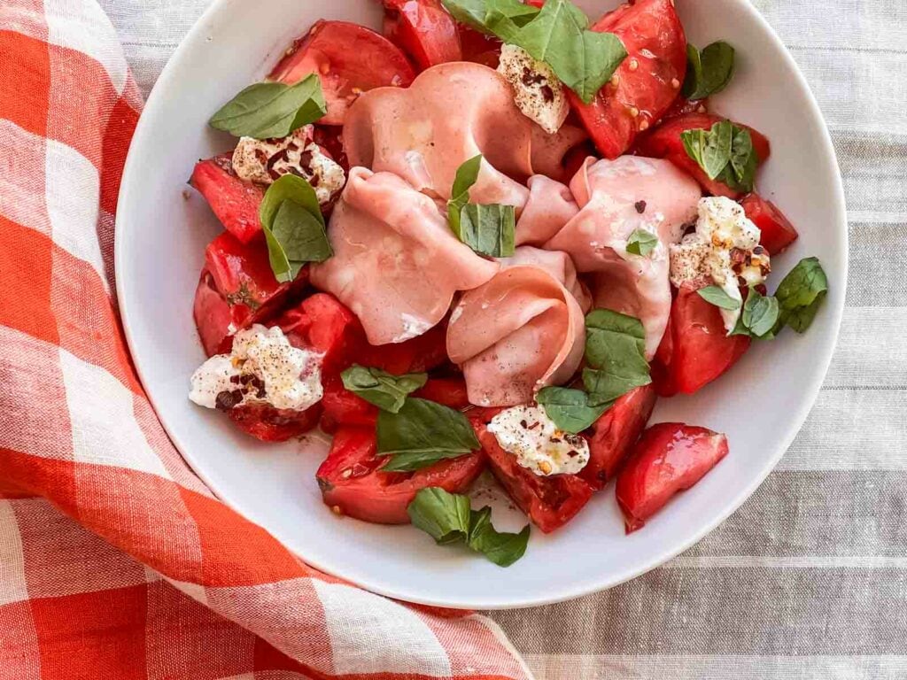 Tomato Mortadella salad over a gingham cloth
