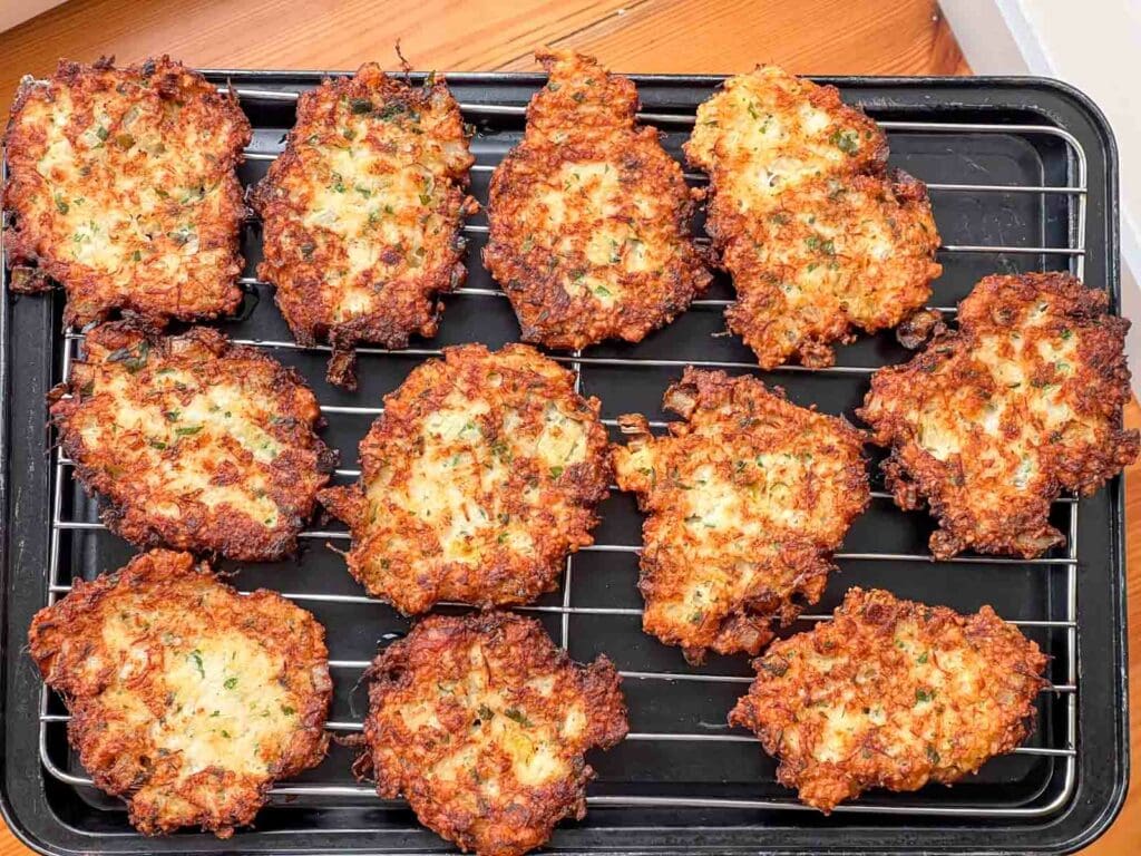 Passover Salt Cod latkes draining on a cooling rack