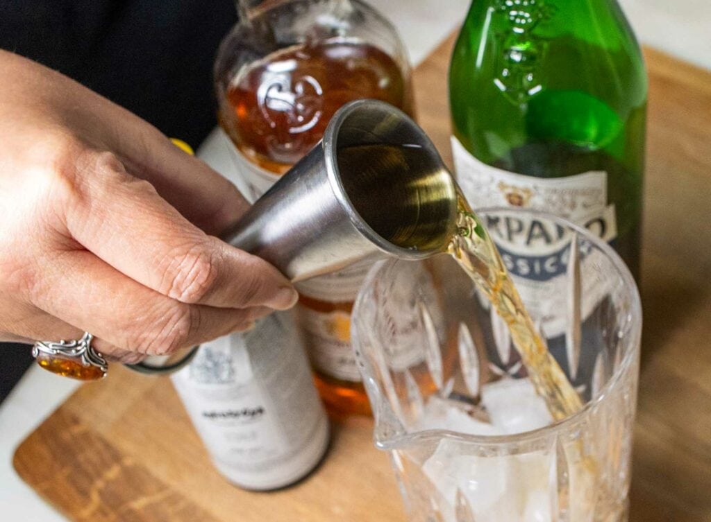 Pouring Scotch into a Rob Roy Cocktail