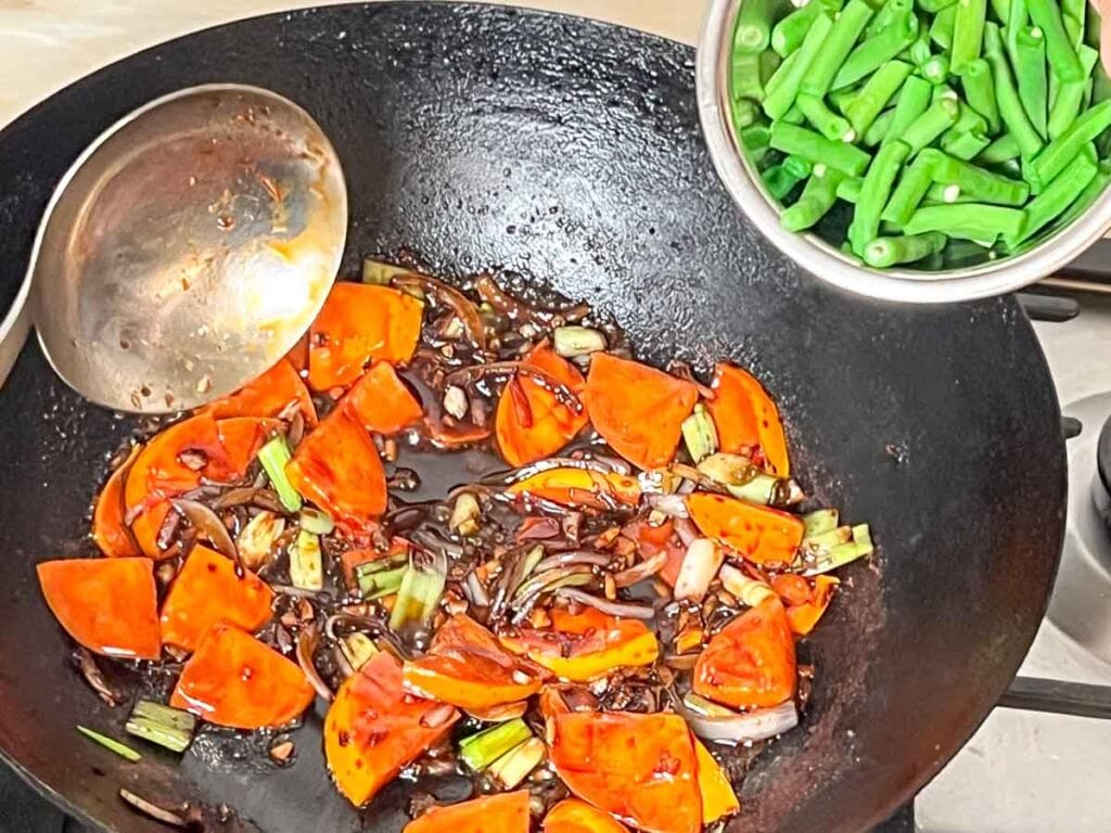 Adding green beans to the wok