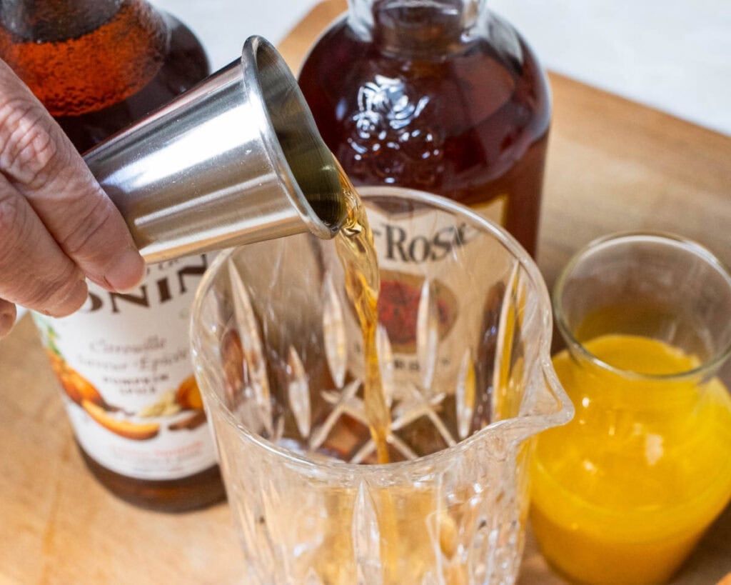 Pouring Bourbon into a Pumpkin Bourbon Smash