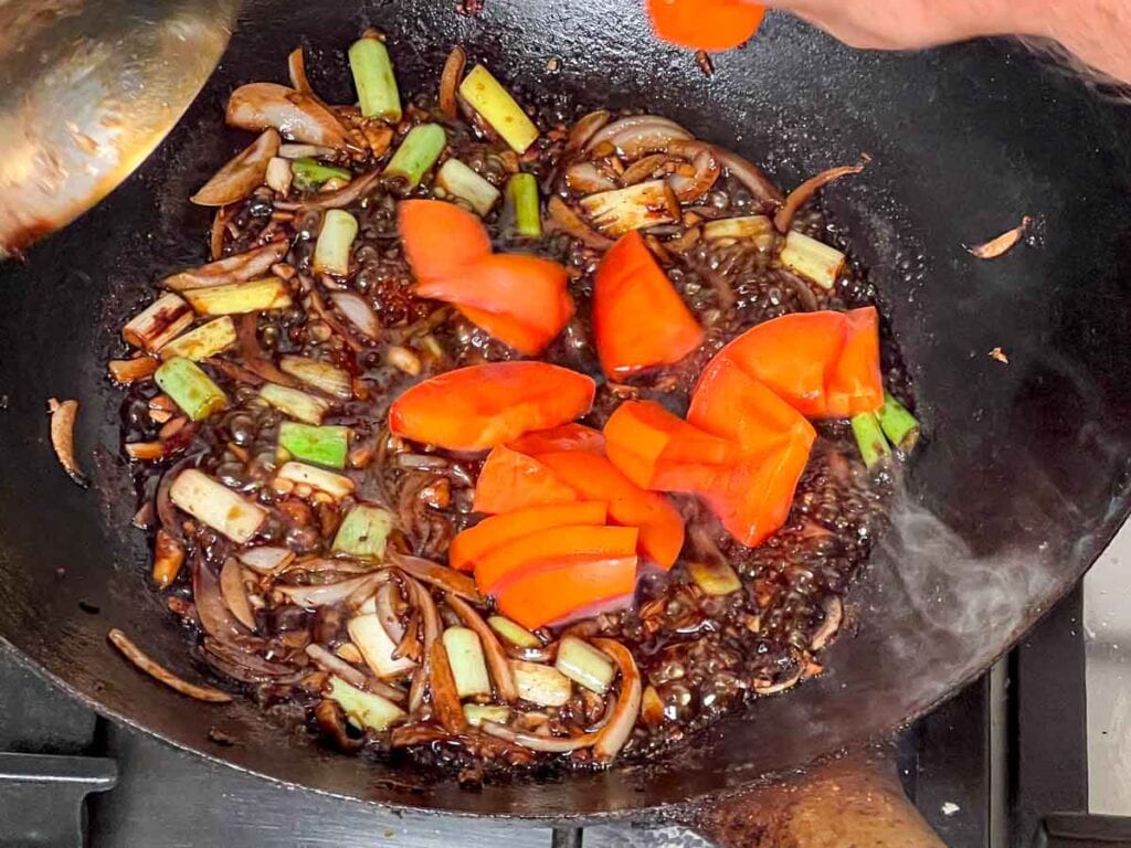 Stir-frying persimmons in a wok