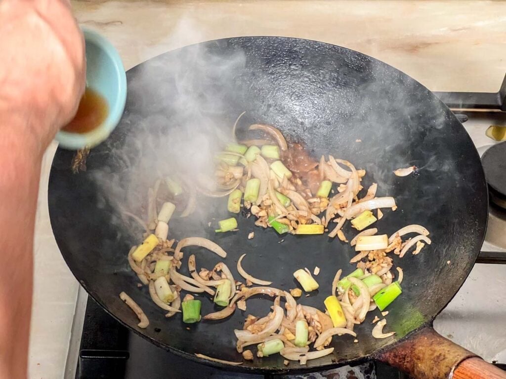 Wok being deglazed with Shaoxing wine